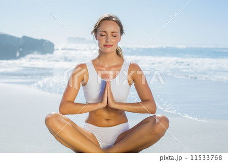 Gorgeous blonde in lotus pose by the sea Gorgeous blonde in lotus pose by the sea 11533768