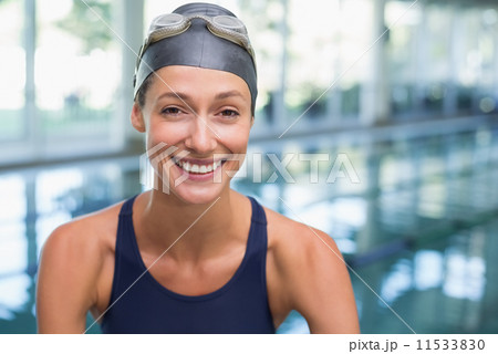 Pretty swimmer smiling at camera by the pool Pretty swimmer smiling at camera by the pool 11533830