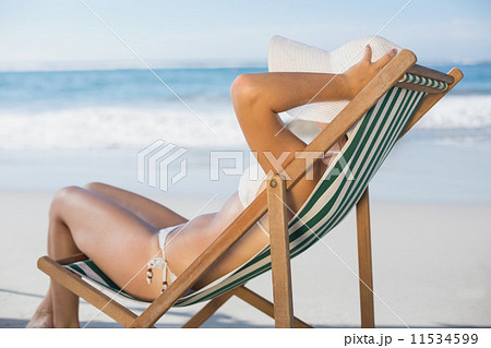 Slim woman relaxing in deck chair on the beach Slim woman relaxing in deck chair on the beach 11534599