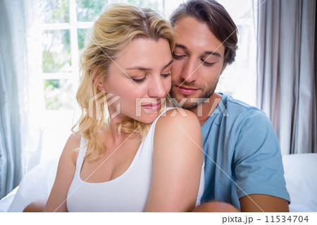 Cute young couple relaxing on bed together Cute young couple relaxing on bed together 11534704