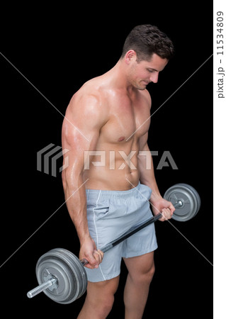 Focused crossfitter lifting up heavy barbell 11534809