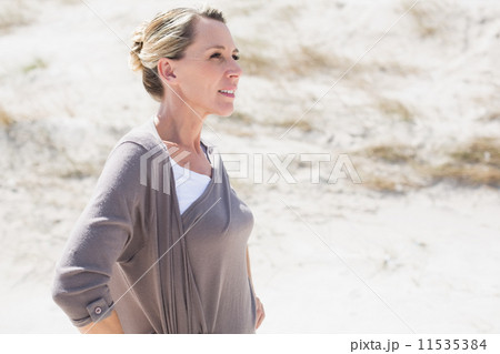 Thinking blonde woman standing on the beach 11535384