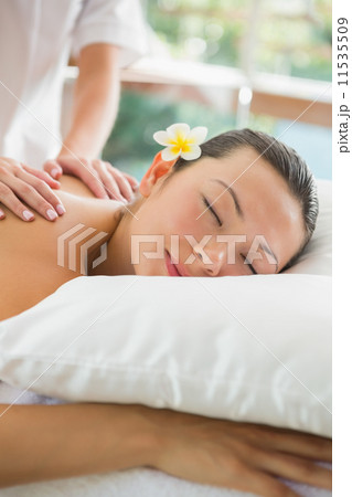 Smiling brunette getting a shoulder massage Smiling brunette getting a shoulder massage 11535509