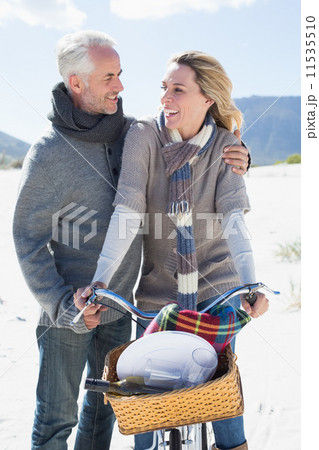 Carefree couple going on a bike ride and picnic on the beach 11535510