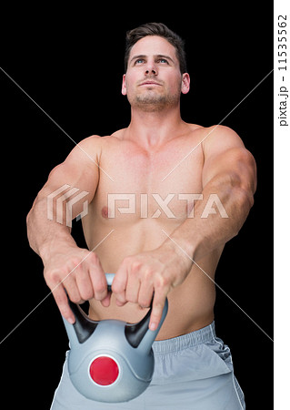 Focused bodybuilder swinging up kettlebell 11535562