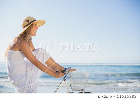 Beautiful blonde in white sundress on bike ride at the beach 11535585