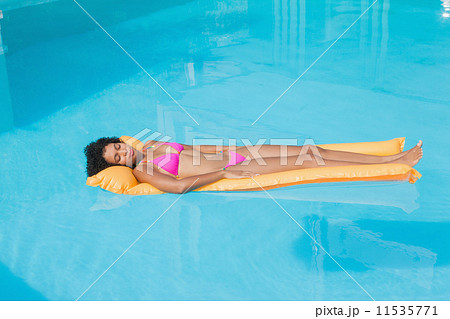 Fit woman lying on lilo in swimming pool Fit woman lying on lilo in swimming pool 11535771