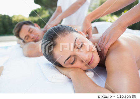 Attractive couple enjoying couples massage poolside 11535889