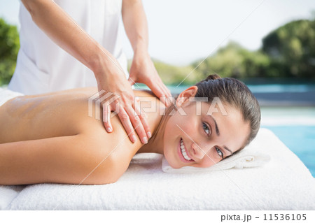 Happy brunette getting a massage poolside 11536105