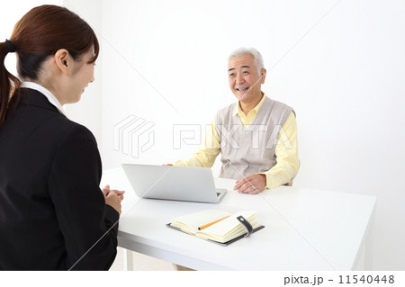 シニア男性に説明するスーツの女性 シニア男性に説明するスーツの女性 11540448