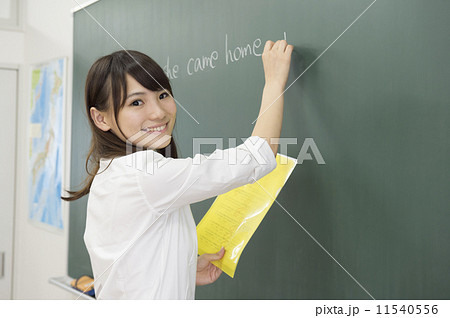 黒板に文字を書く高校生の写真素材