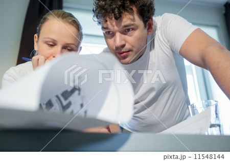 Two young architecs working with blueprints 11548144