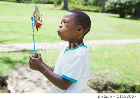 Little boy blowing pinwheel in the park Little boy blowing pinwheel in the park 11552067
