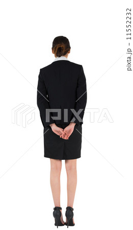 Businesswoman in suit standing with hands behind back 11552232