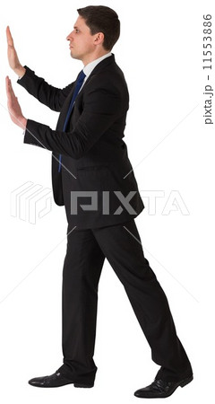 Businessman in suit pushing with hands 11553886
