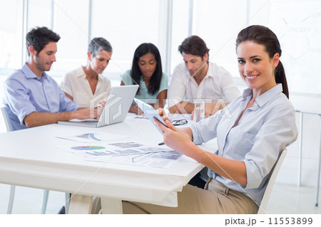Pretty businesswoman using tablet device in business meeting 11553899