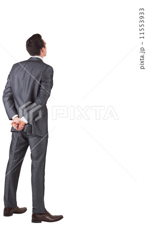 Businessman standing with hands behind back 11553933