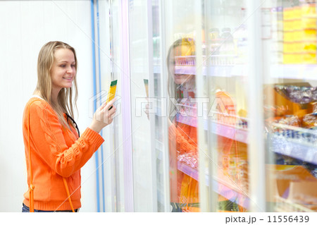 Woman taking product from the showcase Woman taking product from the showcase 11556439