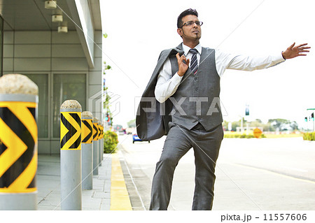 Young businessman hailing for a taxi on the street 11557606