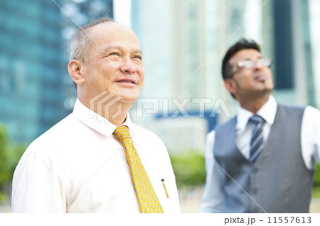 Senior executive looking at a direction while young executive at background Senior executive looking at a direction while young executive at background 11557613