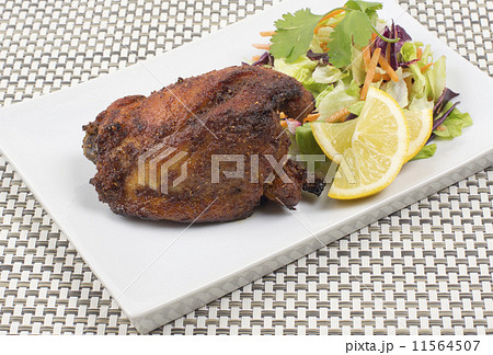 Tandoori chicken served with salad, mint raita and lemon slices  11564507