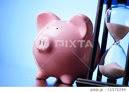 Pink piggy bank with a vintage hourglass behind Pink piggy bank with a vintage hourglass behind 11572294