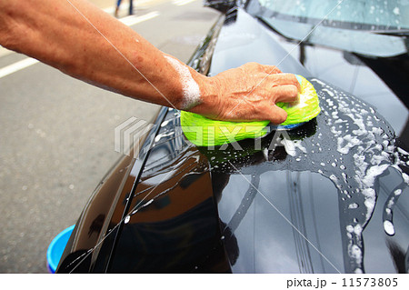 hand hold sponge over the car for washing 11573805