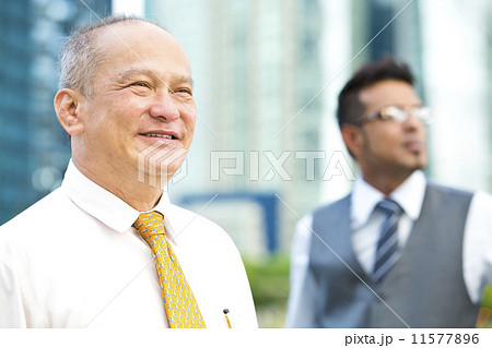 Senior executive looking at a direction while young executive at background Senior executive looking at a direction while young executive at background 11577896