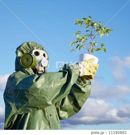 Man in chemical suit and gas mask with plant in hands Man in chemical suit and gas mask with plant in hands 11580862