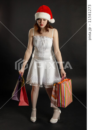 Comical tired woman in New Year's cap with purchases 11581273
