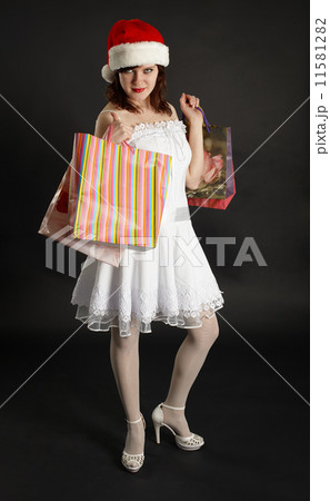 Beautiful girl in Christmas cap with gifts in hands 11581282