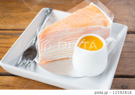 Homemade orange crepe cake serving on the plate Homemade orange crepe cake serving on the plate 11592818