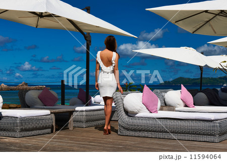 Woman in white dress near poolside 11594064