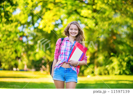 Cheerful college student holding books and folders 11597139