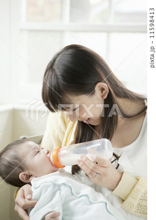 赤ちゃんにミルクを飲ませる母親 11598413
