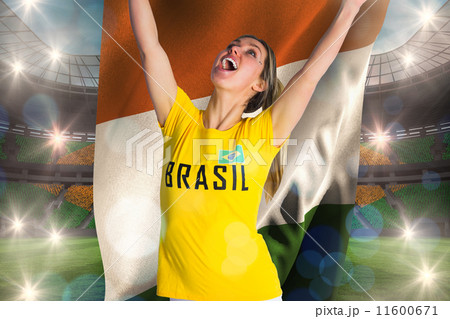 Composite image of pretty football fan in brasil t-shirt holding 11600671