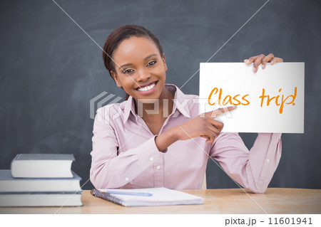 Happy teacher holding page showing class trip 11601941