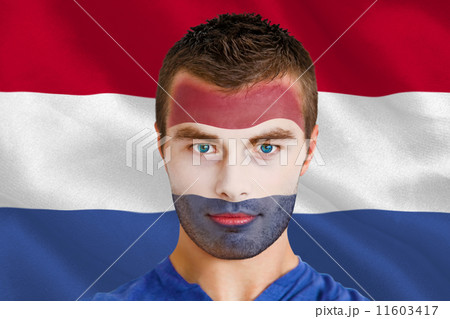 Composite image of serious young netherlands fan with facepaint Composite image of serious young netherlands fan with facepaint 11603417