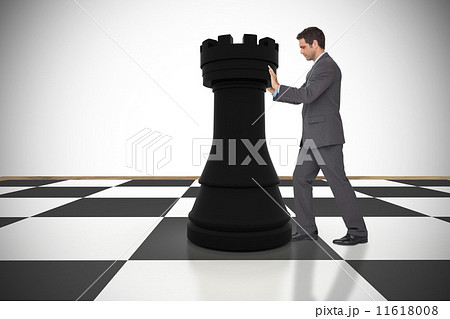 Composite image of businessman pushing chess piece 11618008