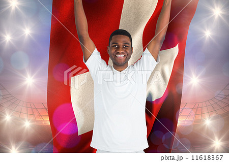 Composite image of excited handsome football fan cheering holdin 11618367