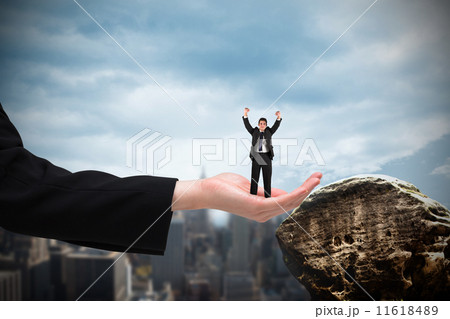 Composite image of businessman cheering at the camera in large h 11618489