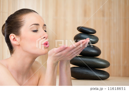 Composite image of beautiful brunette blowing over hands 11618651