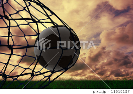 Composite image of football in back of the net 11619137