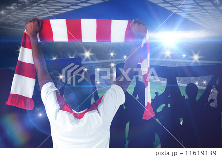 Composite image of happy football fan waving scarf 11619139