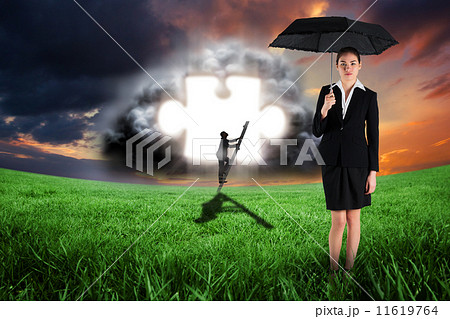 Composite image of young businesswoman holding umbrella 11619764