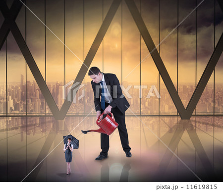Composite image of businessman watering tiny businesswoman 11619815