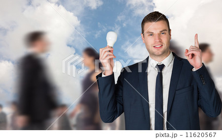 Composite image of businessman holding light bulb and pointing Composite image of businessman holding light bulb and pointing 11620567