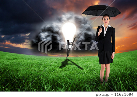 Composite image of young businesswoman holding umbrella 11621094
