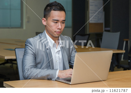 Successful asian Bbsinessman working on a laptop in his office 11621787