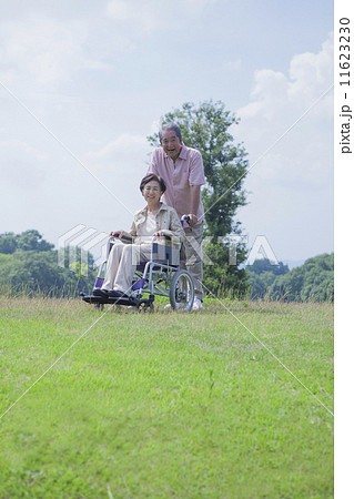 車椅子で散歩をする夫婦 11623230
